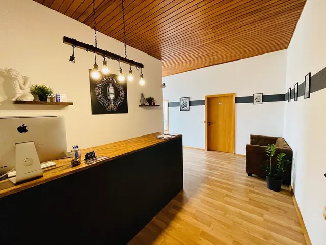 Empfangstheke mit Holzdecke und Hängeleuchten
