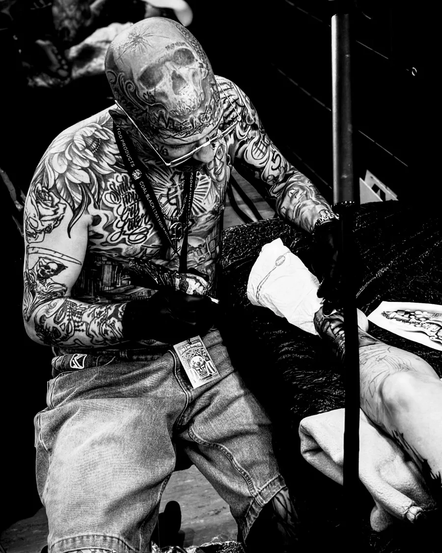 Schwarz-Weiß-Foto: Tattoo Artist Martin bei der Arbeit an einem Kunden
